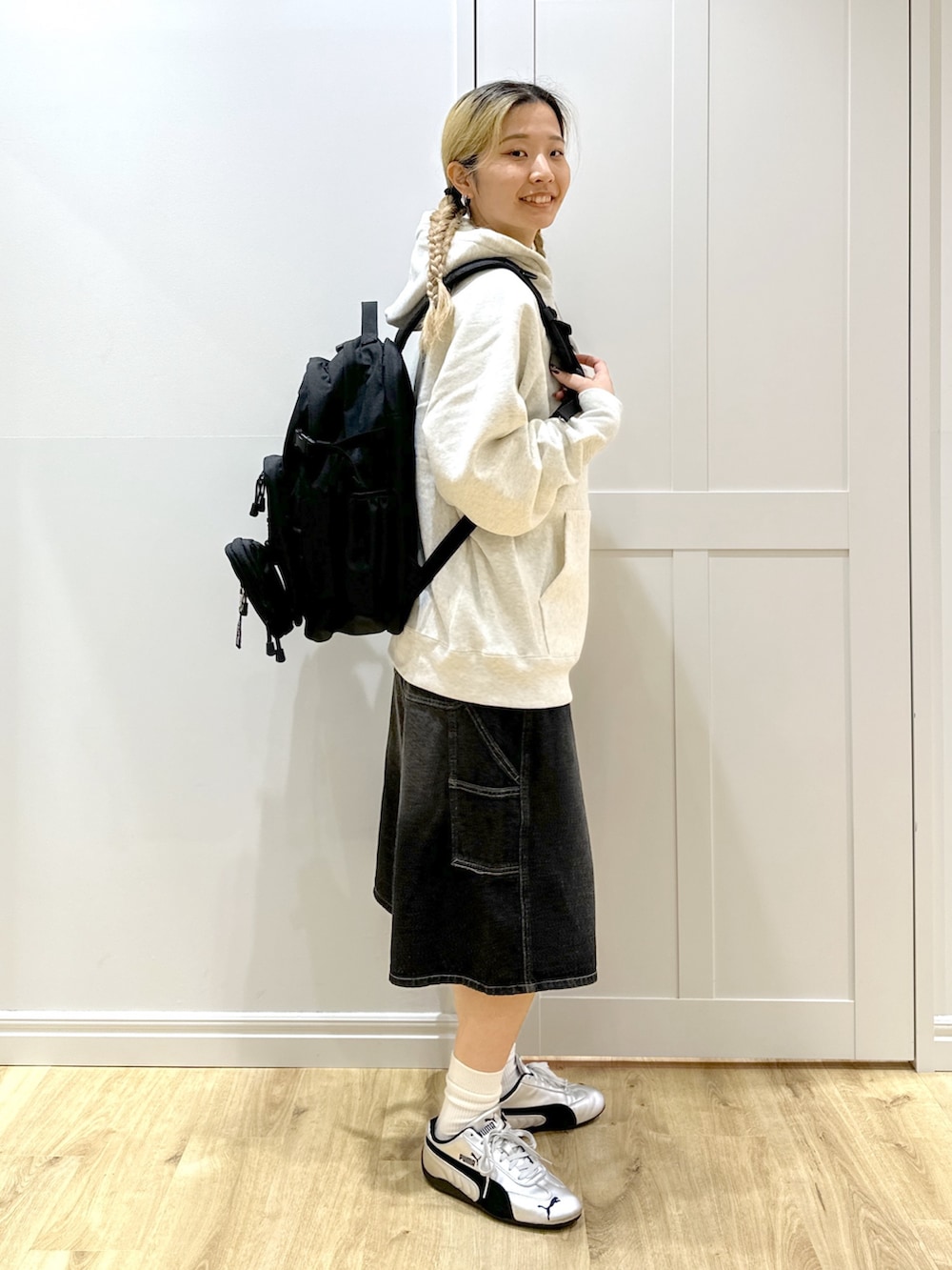 ベージュ系のパーカー、ブラック系のデニムパンツ、ブラック系のバックパック/リュックを着用したレディースの秋コーディネートの3枚目の写真