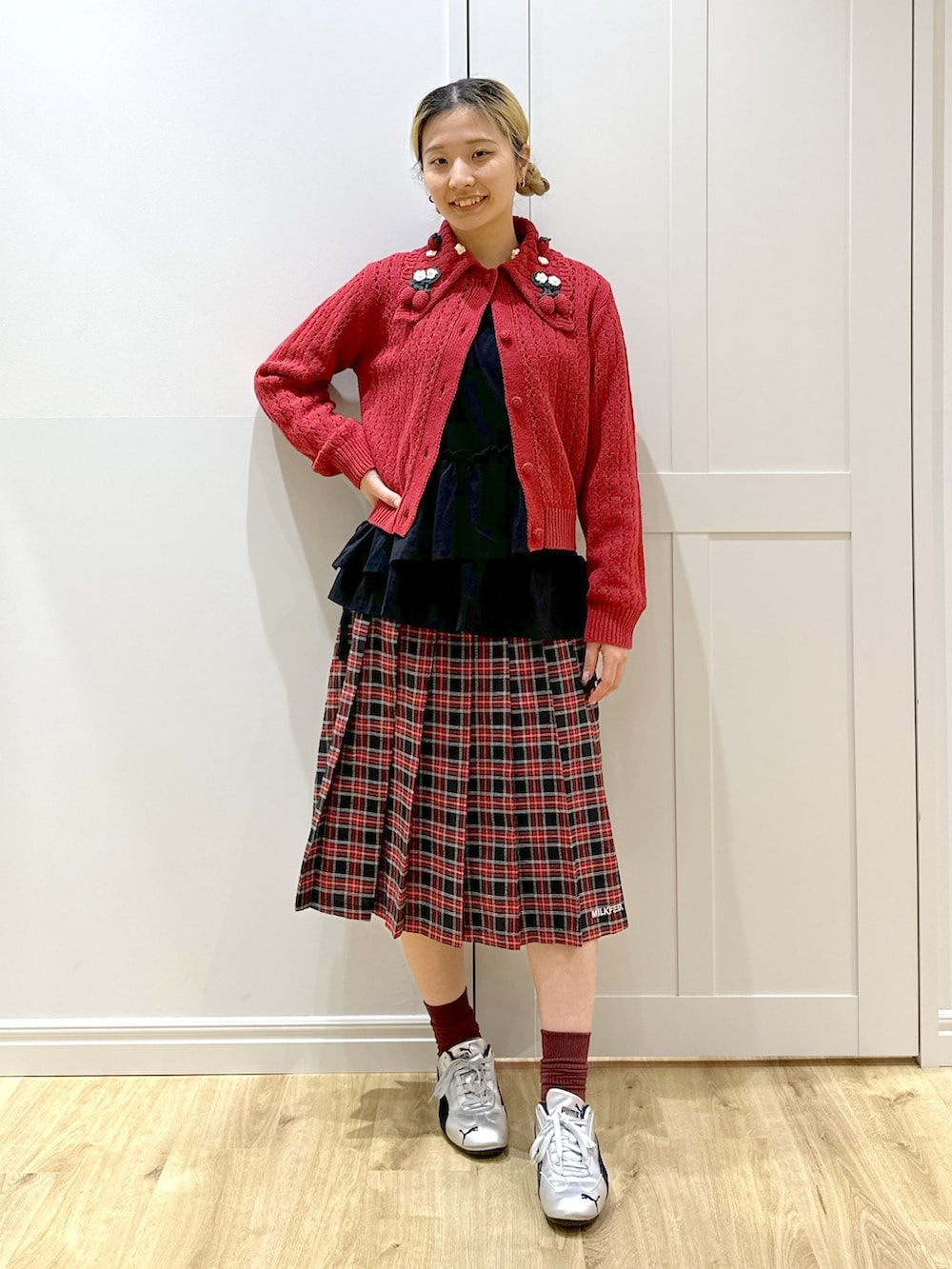 レッド系のカーディガン/ボレロ、ホワイト系のTシャツ/カットソー、ブラック系のスカートを着用したレディースの秋コーディネートの3枚目の写真