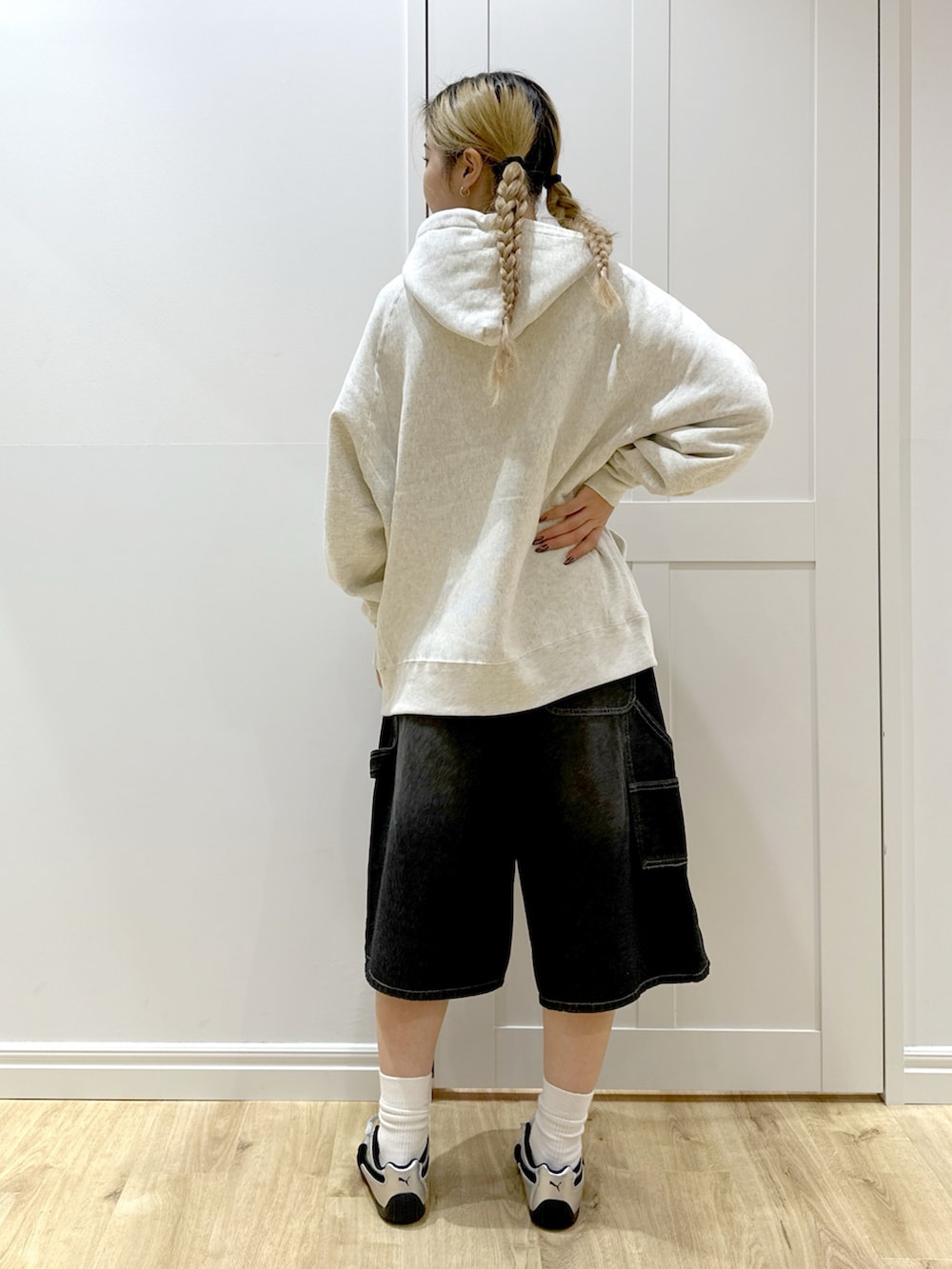 ベージュ系のパーカー、ブラック系のデニムパンツ、ブラック系のバックパック/リュックを着用したレディースの秋コーディネートの4枚目の写真