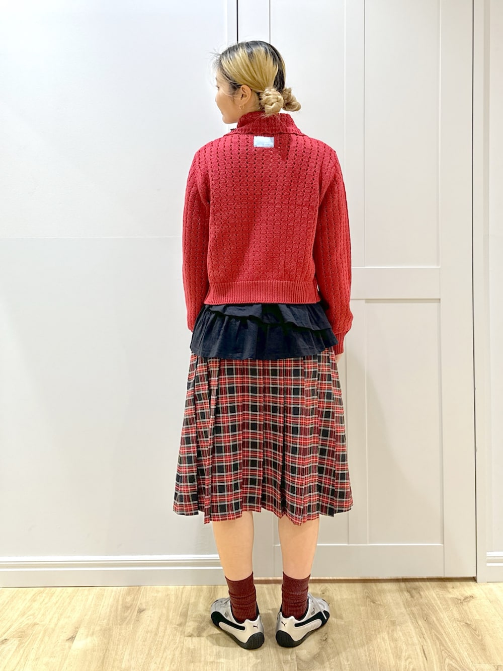 レッド系のカーディガン/ボレロ、ホワイト系のTシャツ/カットソー、ブラック系のスカートを着用したレディースの秋コーディネートの4枚目の写真