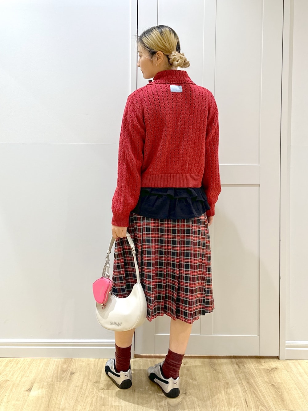 レッド系のカーディガン/ボレロ、ホワイト系のTシャツ/カットソー、ブラック系のスカートを着用したレディースの秋コーディネートの2枚目の写真