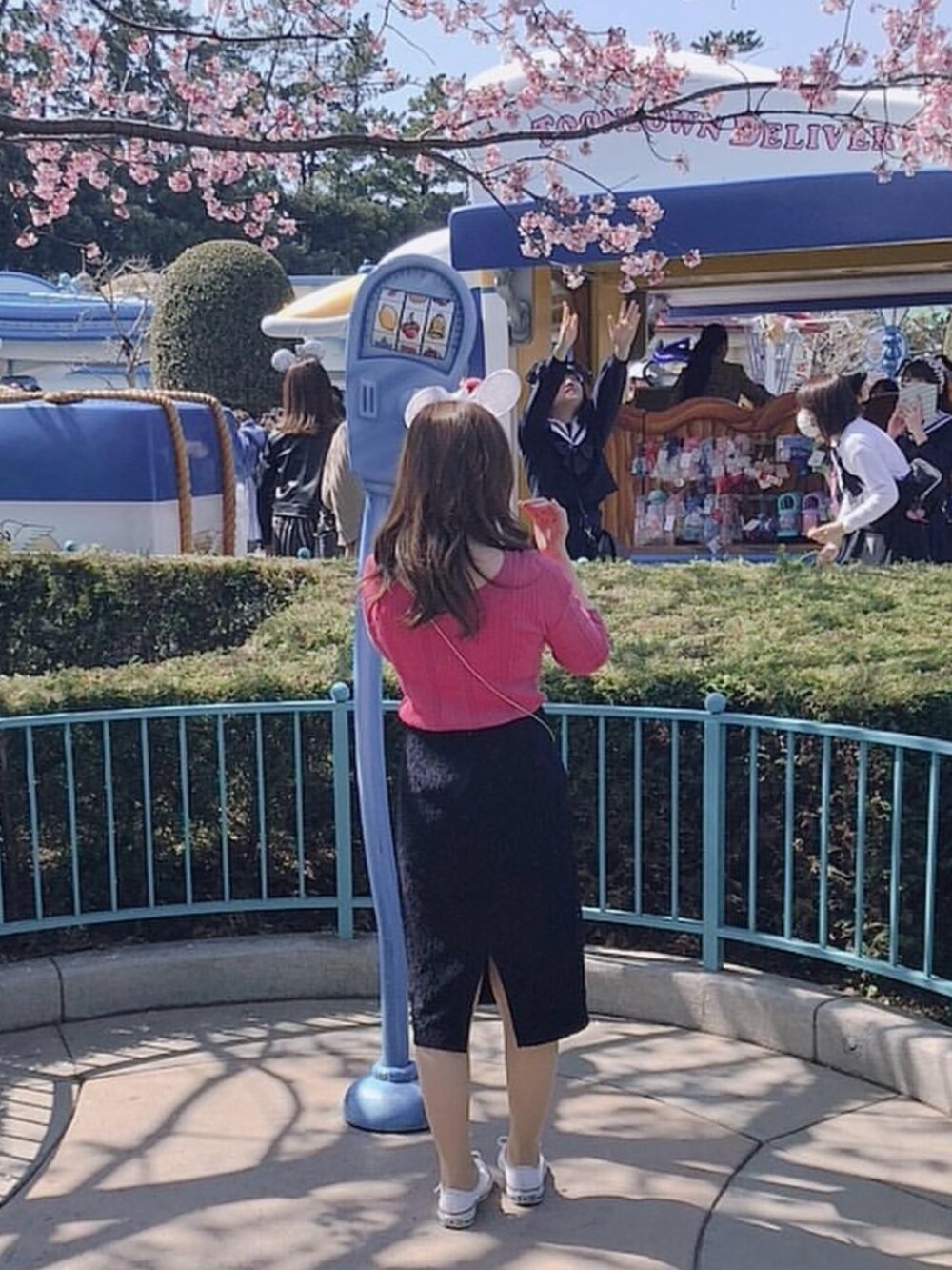 ブルー系のスカート、ピンク系のニット/セーター、グリーン系のミリタリージャケットを着用したレディースの冬コーディネートの2枚目の写真