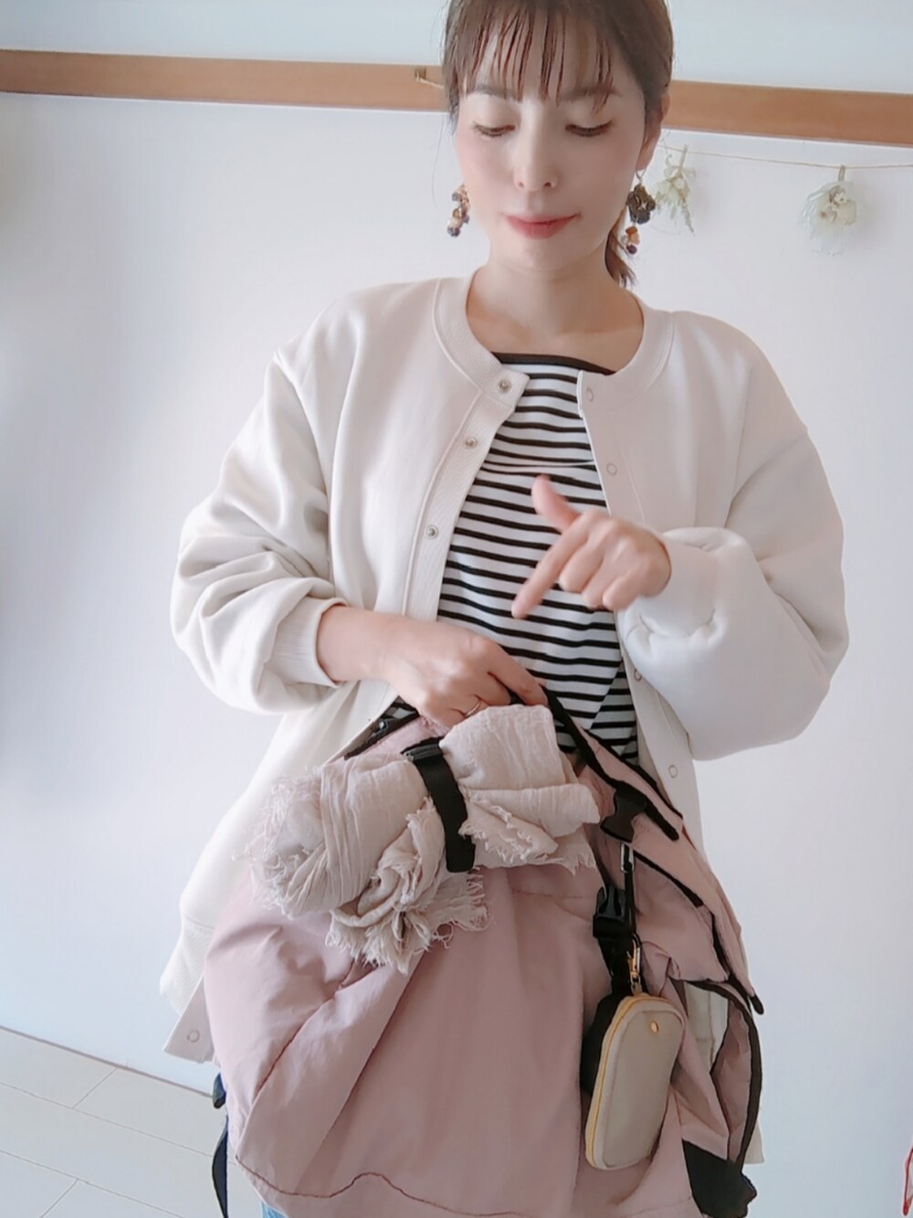 ホワイト系のジャケット/アウター、ピンク系のバッグを着用したレディースの春コーディネートの3枚目の写真