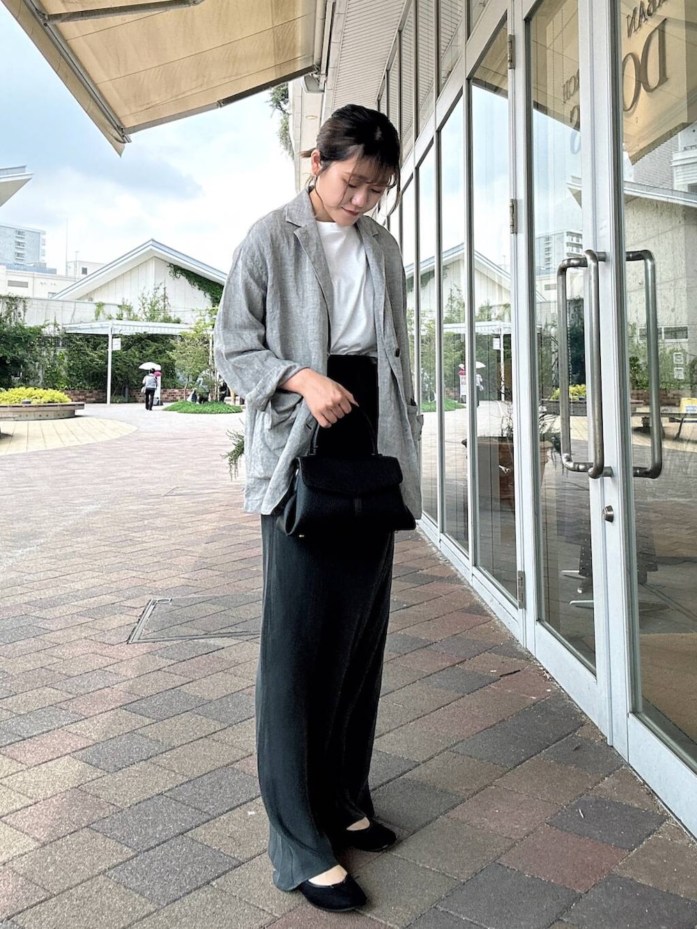 ホワイト系のTシャツ/カットソー、ブラック系のバレエシューズ、ブラック系のショルダーバッグを着用したレディースの夏コーディネートの3枚目の写真