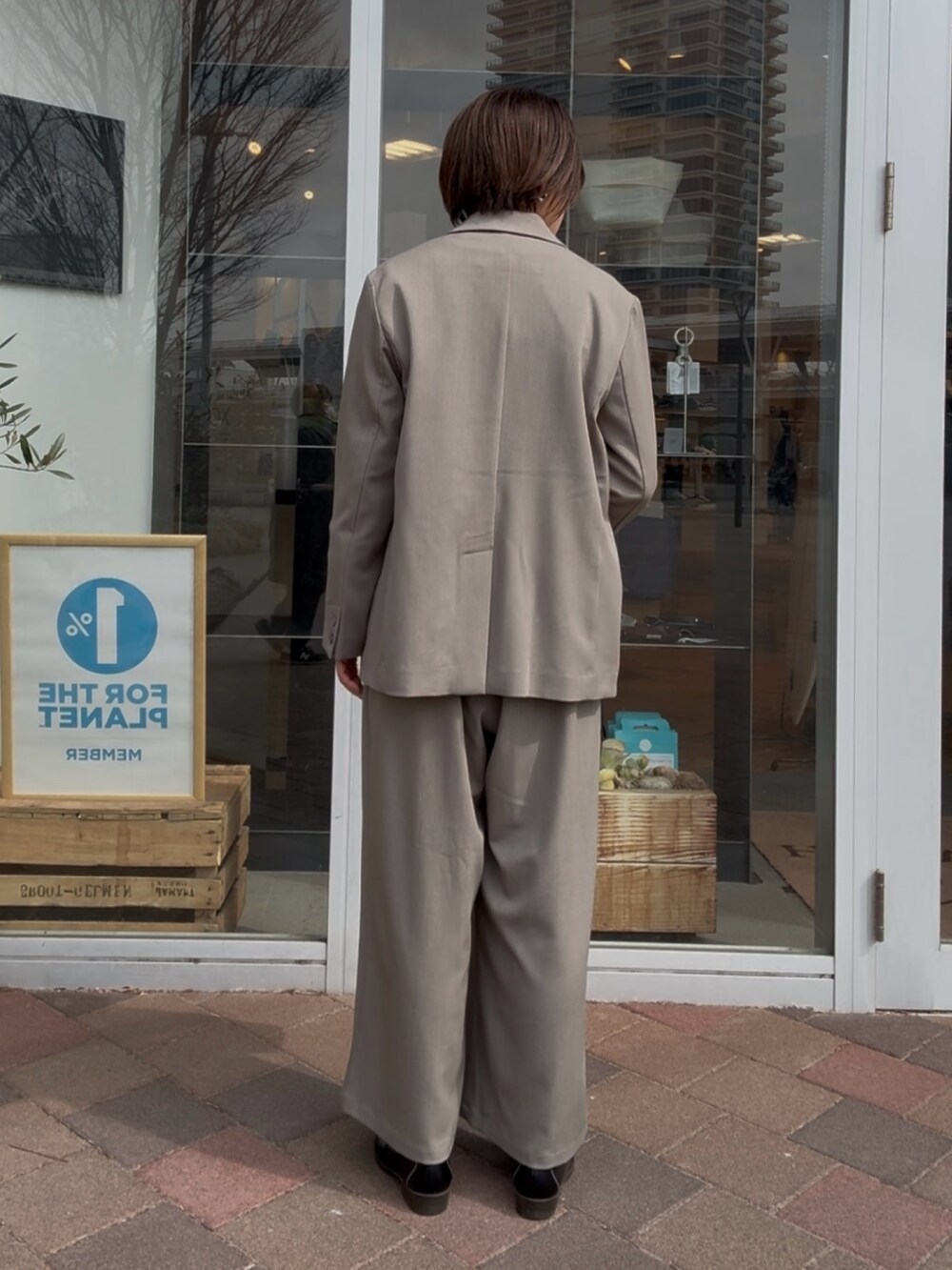 グレー系のその他アウター、グレー系のその他パンツ、ホワイト系のニット/セーターを着用したレディースの冬コーディネートの6枚目の写真