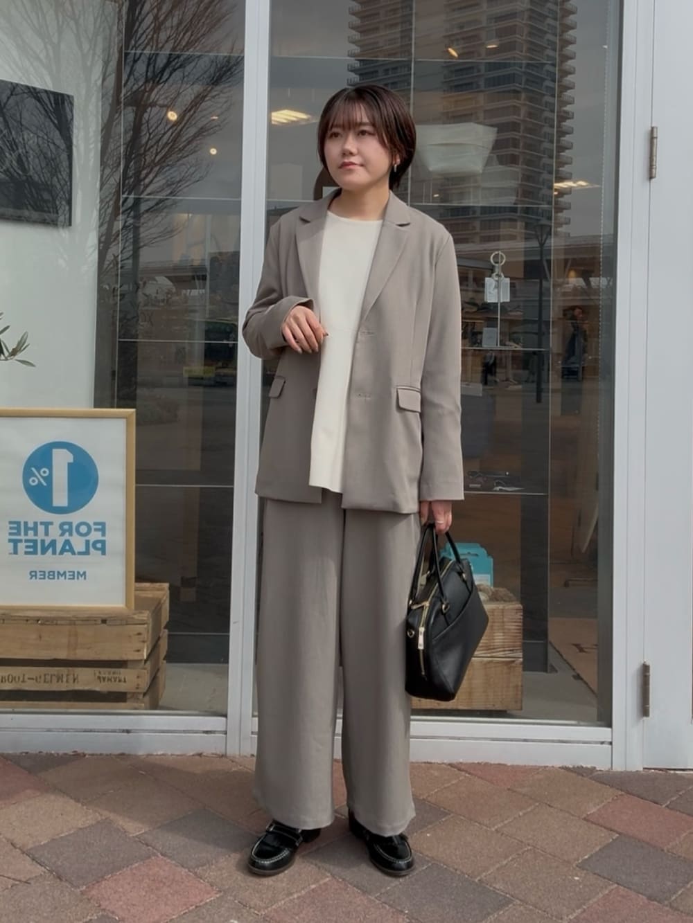 グレー系のその他アウター、グレー系のその他パンツ、ホワイト系のニット/セーターを着用したレディースの冬コーディネートの2枚目の写真