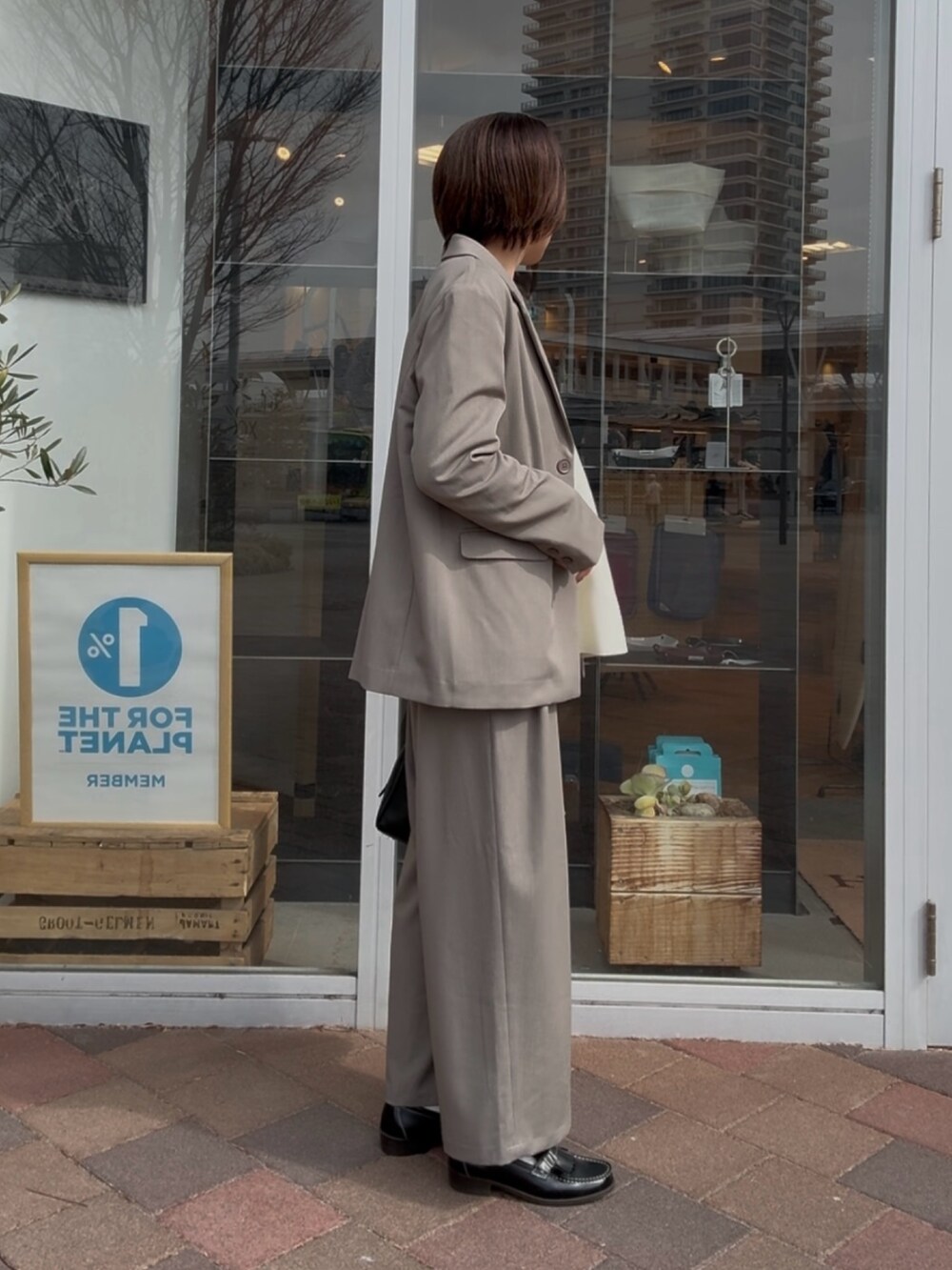 グレー系のその他アウター、グレー系のその他パンツ、ホワイト系のニット/セーターを着用したレディースの冬コーディネートの5枚目の写真