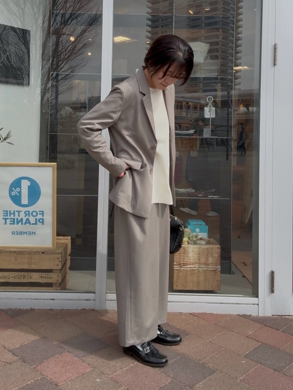 グレー系のその他アウター、グレー系のその他パンツ、ホワイト系のニット/セーターを着用したレディースの冬コーディネートの4枚目の写真