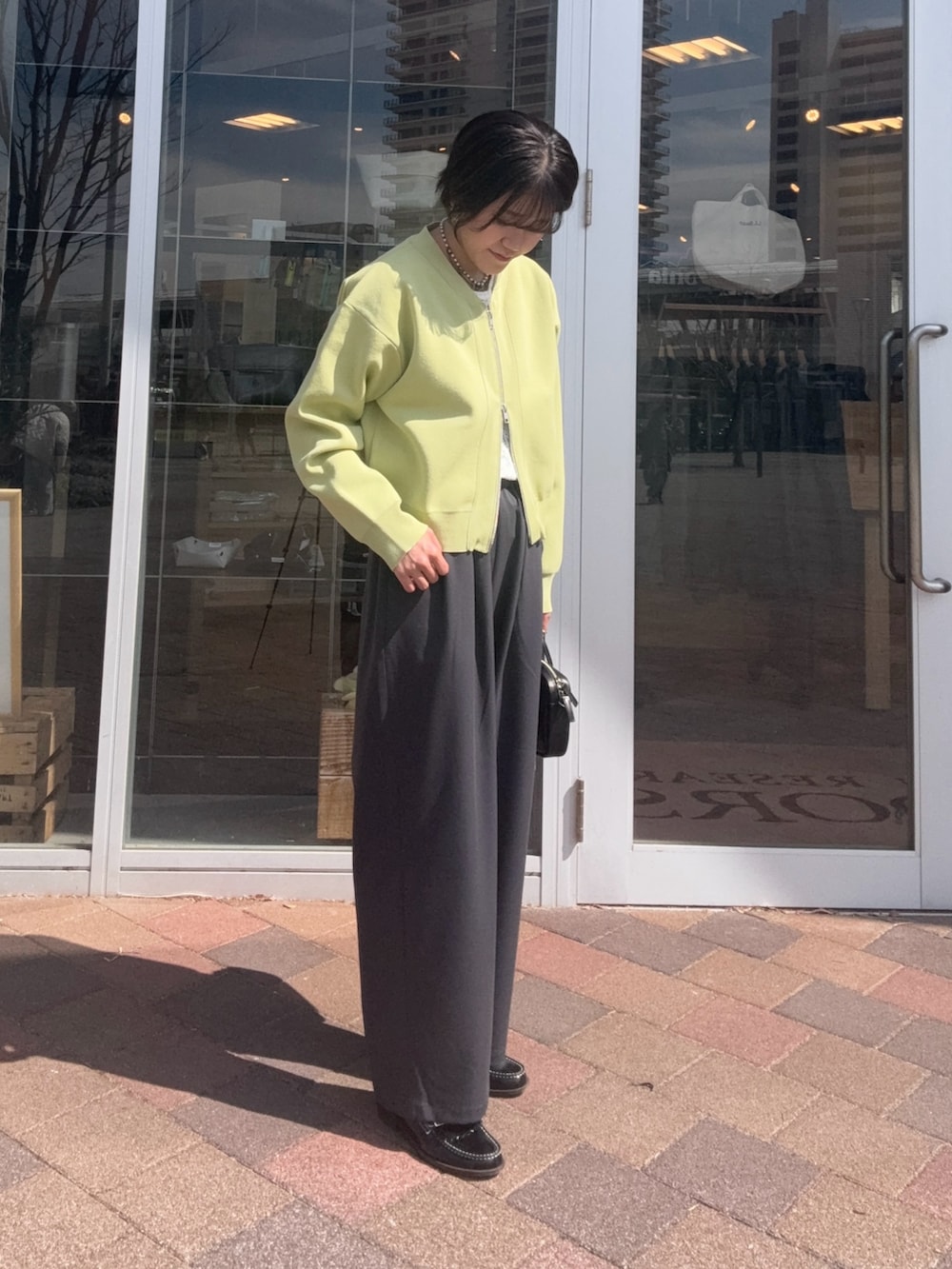 グレー系のその他パンツ、ホワイト系のTシャツ/カットソー、グリーン系のカーディガン/ボレロを着用したレディースの春コーディネートの4枚目の写真