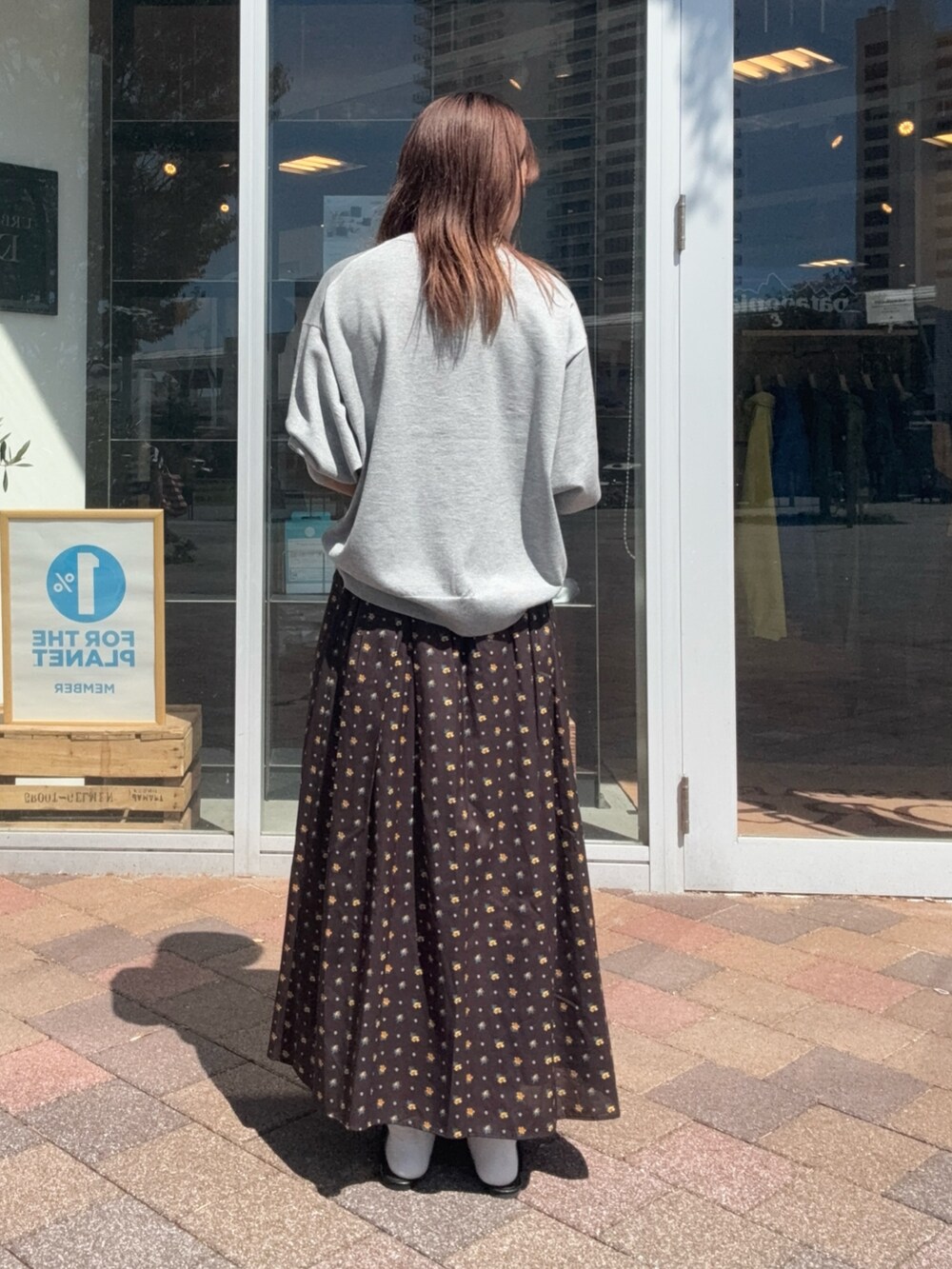 ブラック系のスカート、ブラック系のハンドバッグ、グレー系のニット/セーターを着用したレディースの秋コーディネートの5枚目の写真