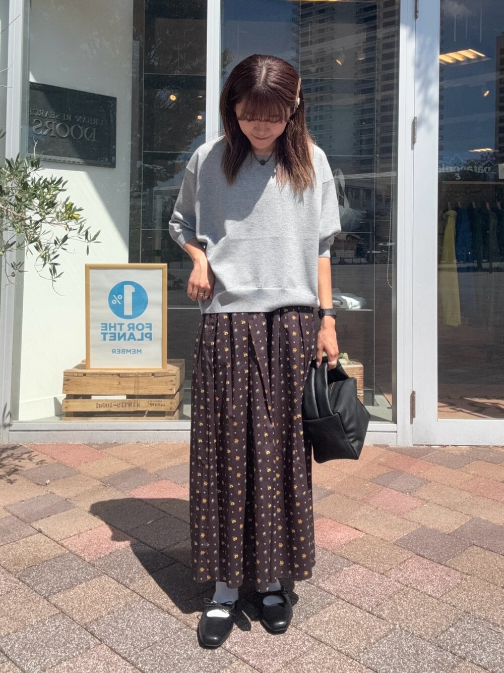 ブラック系のスカート、ブラック系のハンドバッグ、グレー系のニット/セーターを着用したレディースの秋コーディネートの3枚目の写真