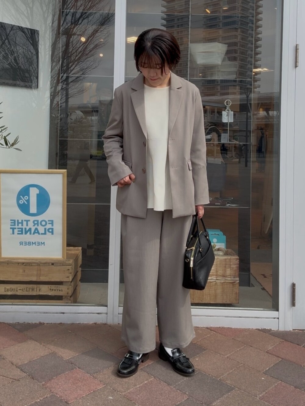 グレー系のその他アウター、グレー系のその他パンツ、ホワイト系のニット/セーターを着用したレディースの冬コーディネートの3枚目の写真