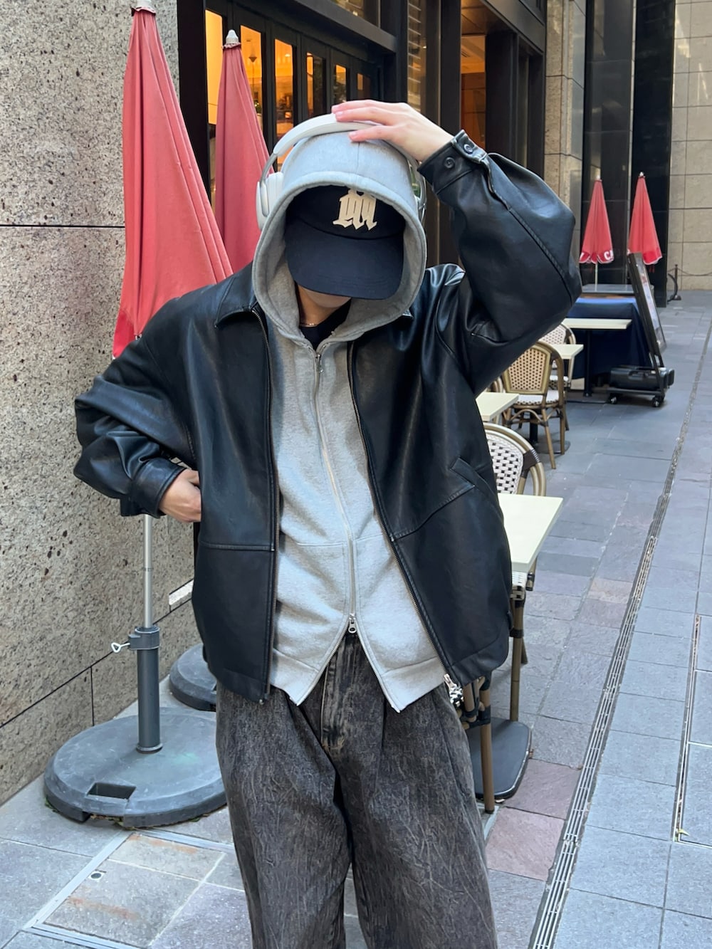 グレー系のパーカー、ブラウン系のデニムパンツ、ブラウン系のローファーを着用したメンズの冬コーディネートの2枚目の写真