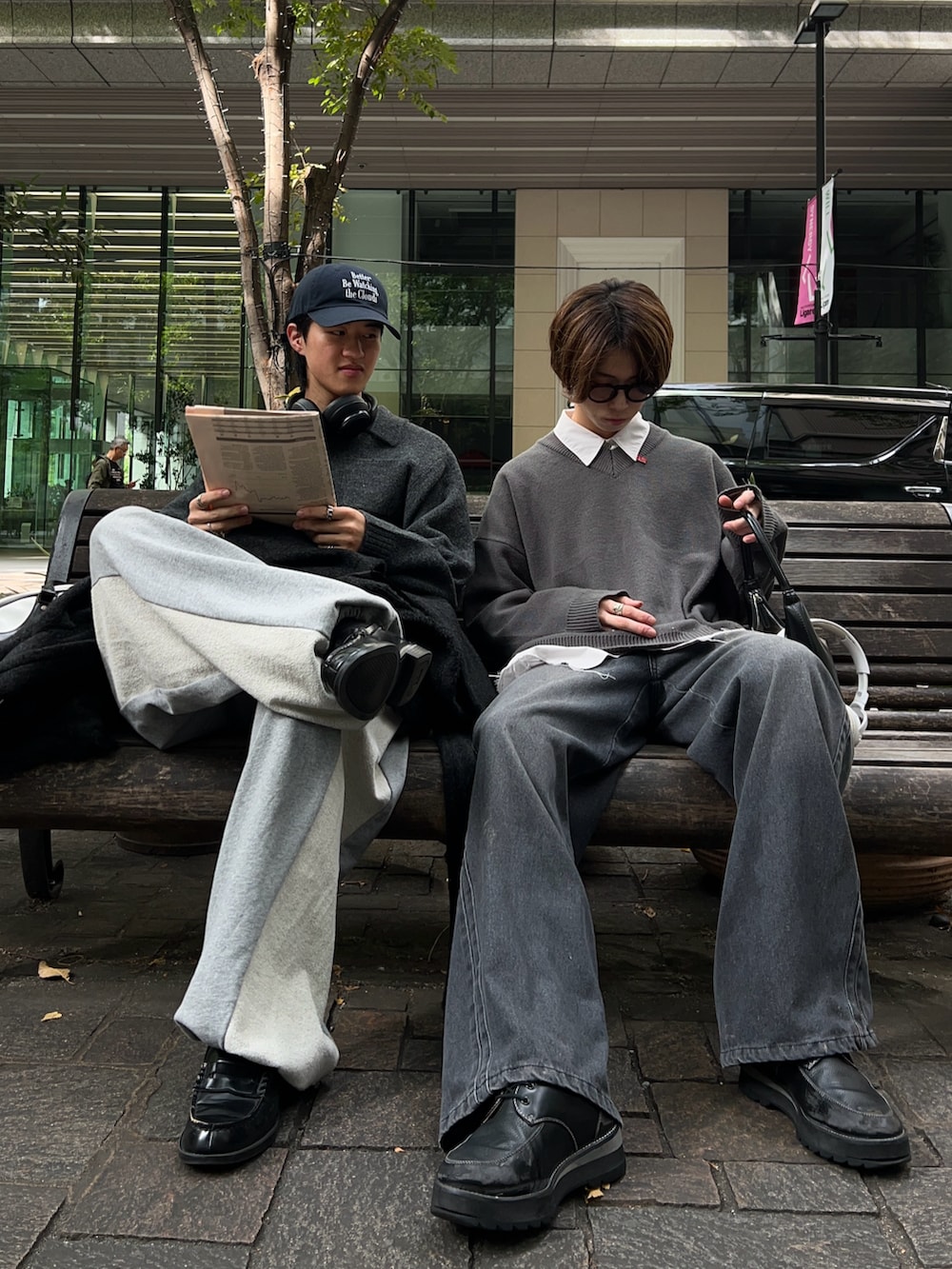 グレー系のトレンチコート、グレー系のスウェットパンツ、ブラック系のローファーを着用したメンズの秋コーディネートの5枚目の写真