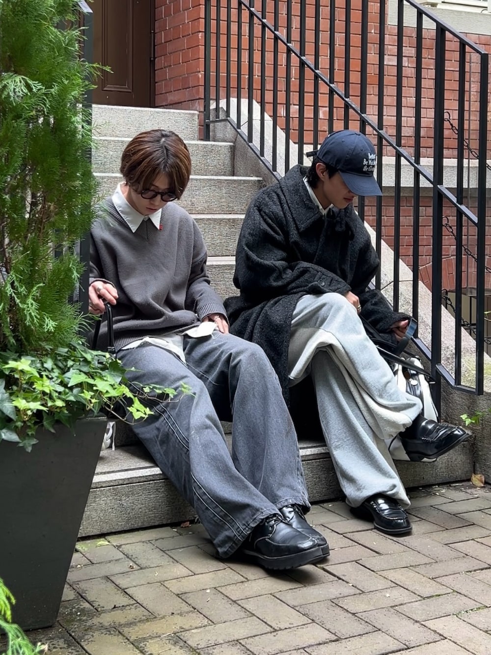 グレー系のトレンチコート、グレー系のスウェットパンツ、ブラック系のローファーを着用したメンズの秋コーディネートの3枚目の写真