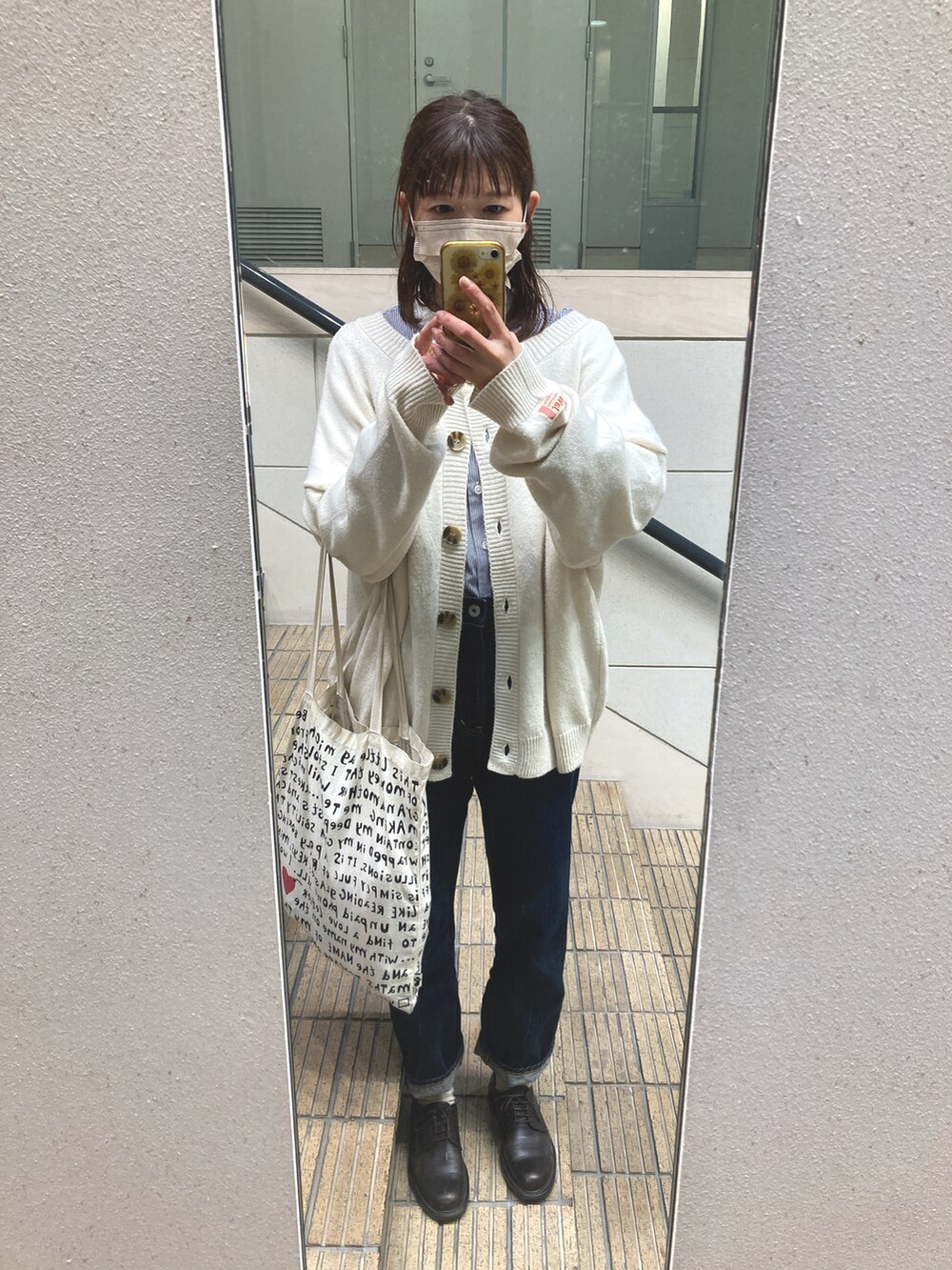 ブルー系のデニムパンツ、ホワイト系のカーディガン/ボレロ、ブルー系のシャツ/ブラウスを着用したレディースの春コーディネートの2枚目の写真