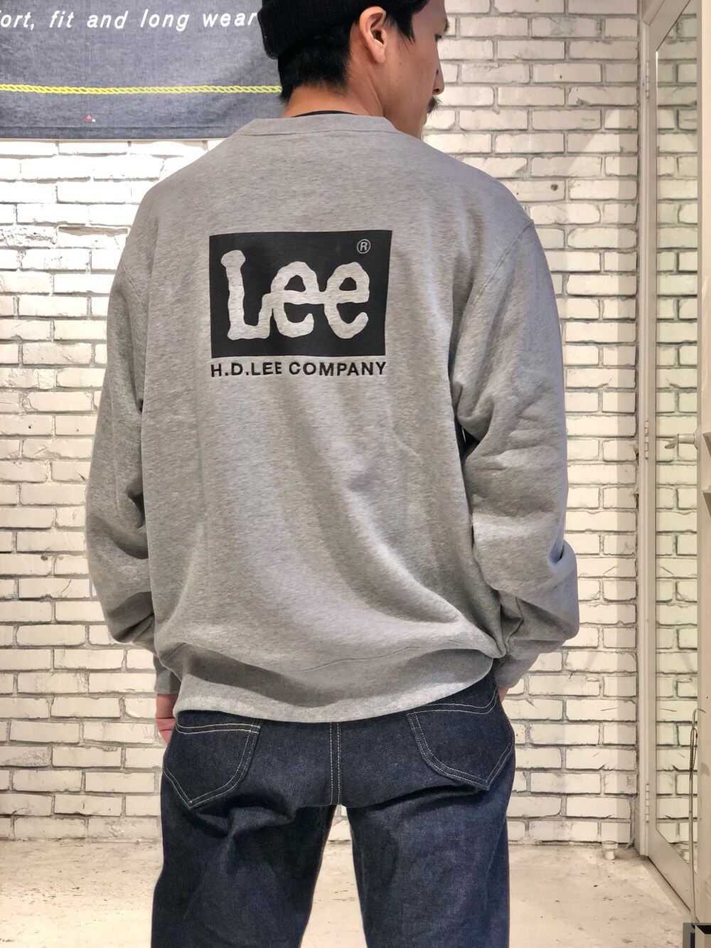 ブラウン系のブーツ、ブルー系のデニムパンツを着用したメンズの秋コーディネートの2枚目の写真