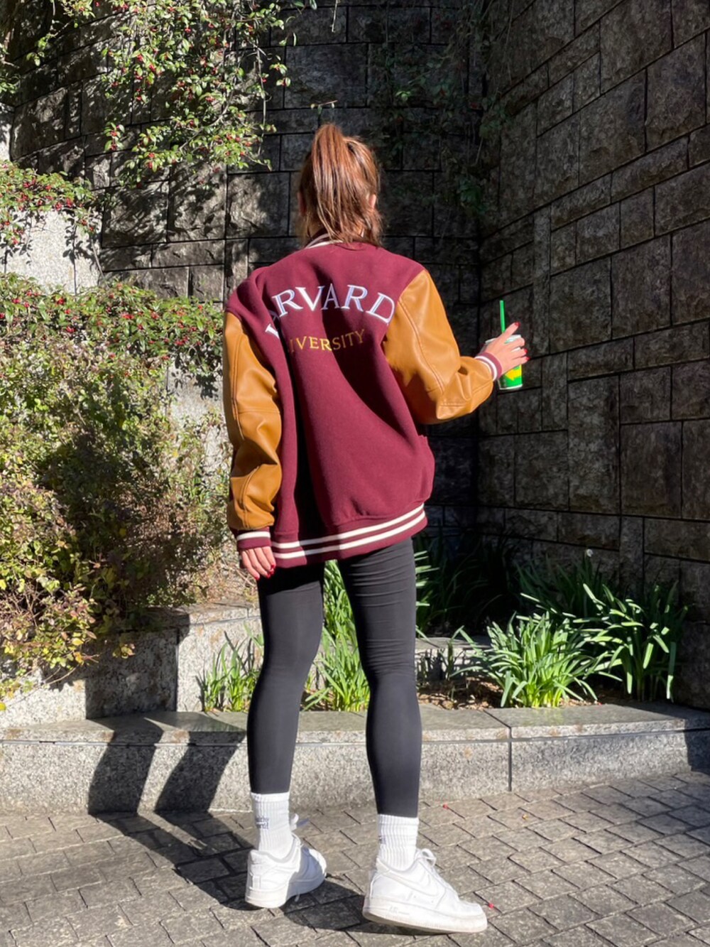 レッド系のスタジャン、ホワイト系のスニーカーを着用したレディースの春コーディネートの2枚目の写真