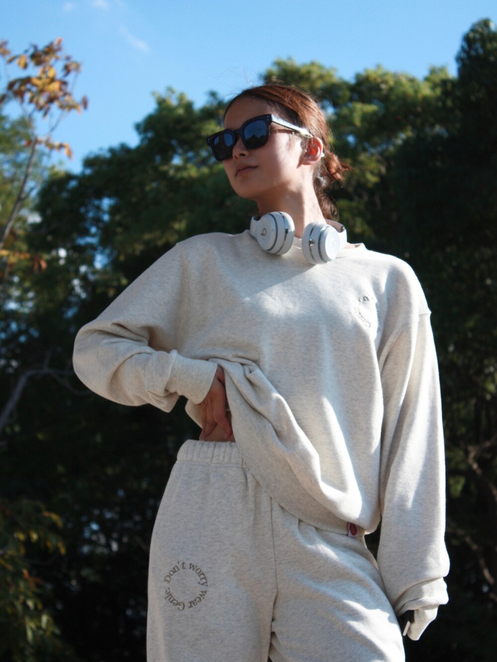 ベージュ系のスウェット、ホワイト系のヘッドフォン/イヤホンを着用したレディースの冬コーディネートの3枚目の写真