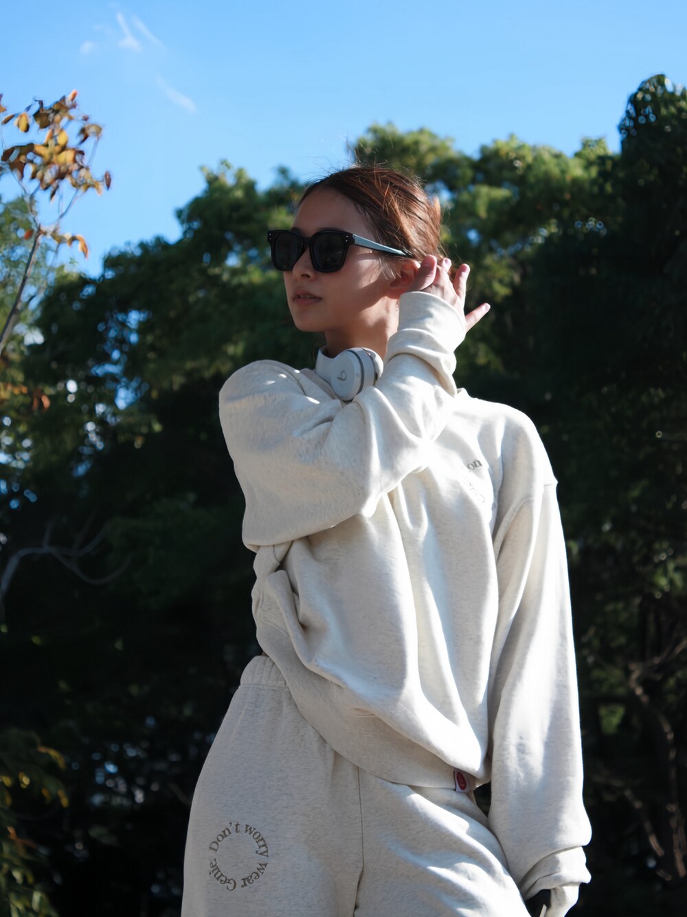 ベージュ系のスウェット、ホワイト系のヘッドフォン/イヤホンを着用したレディースの冬コーディネートの2枚目の写真