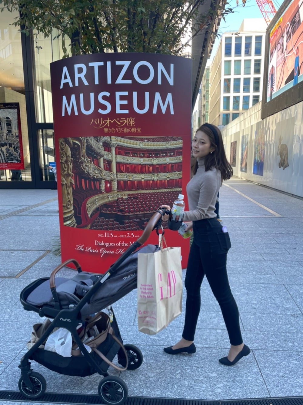 ブラウン系のハンドバッグ、ベージュ系のニット/セーター、ブラック系のデニムパンツを着用したレディースの秋コーディネートの2枚目の写真