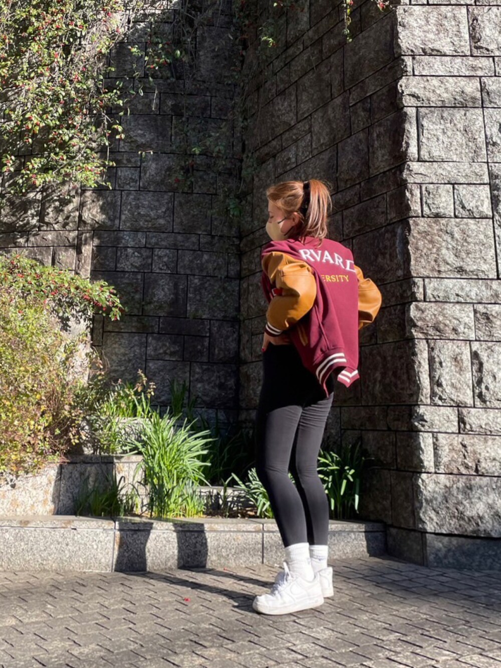 レッド系のスタジャン、ホワイト系のスニーカーを着用したレディースの春コーディネートの3枚目の写真