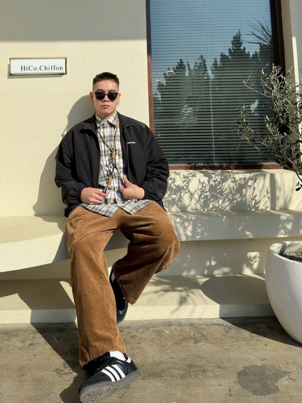 ブラック系のジャケット/アウター、ブラック系のスニーカー、グリーン系のサングラスを着用したメンズの冬コーディネートの2枚目の写真