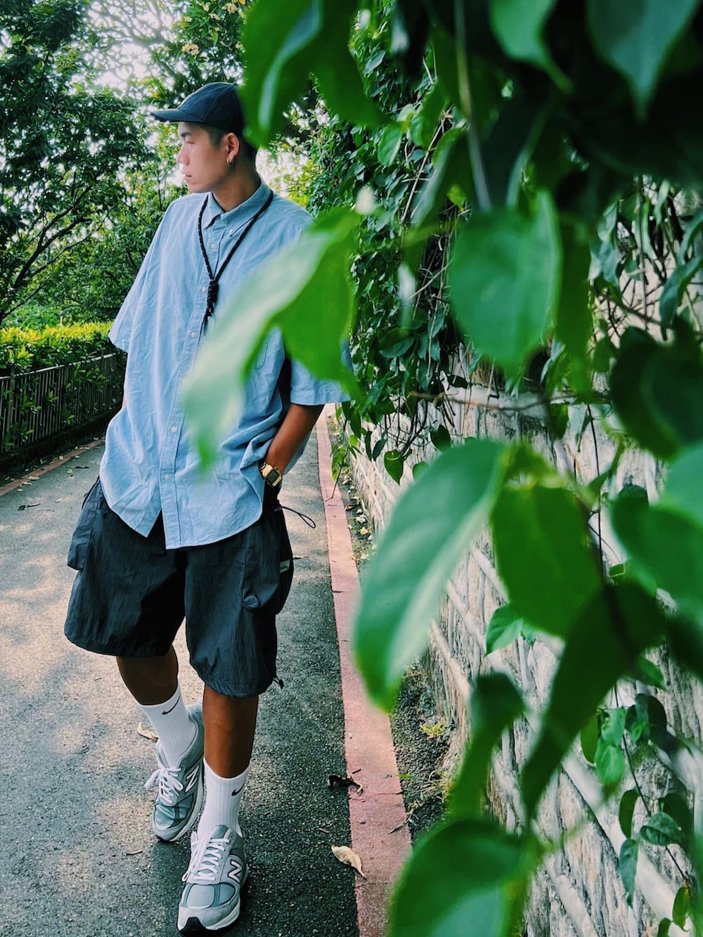 ブルー系のシャツ/ブラウス、グレー系のスニーカー、ブルー系のキャップを着用したメンズの夏コーディネートの2枚目の写真