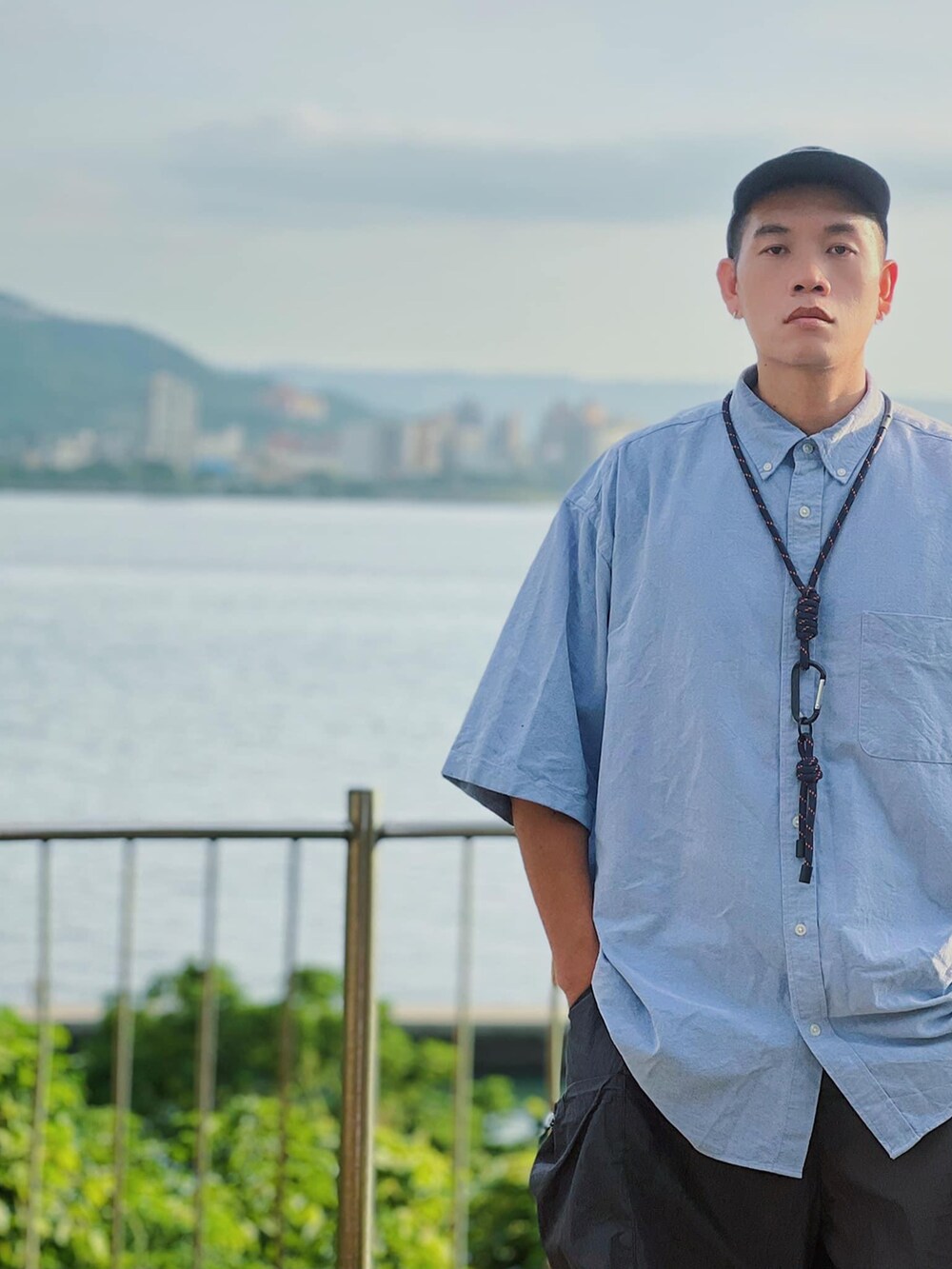 ブルー系のシャツ/ブラウス、グレー系のスニーカー、ブルー系のキャップを着用したメンズの夏コーディネートの4枚目の写真