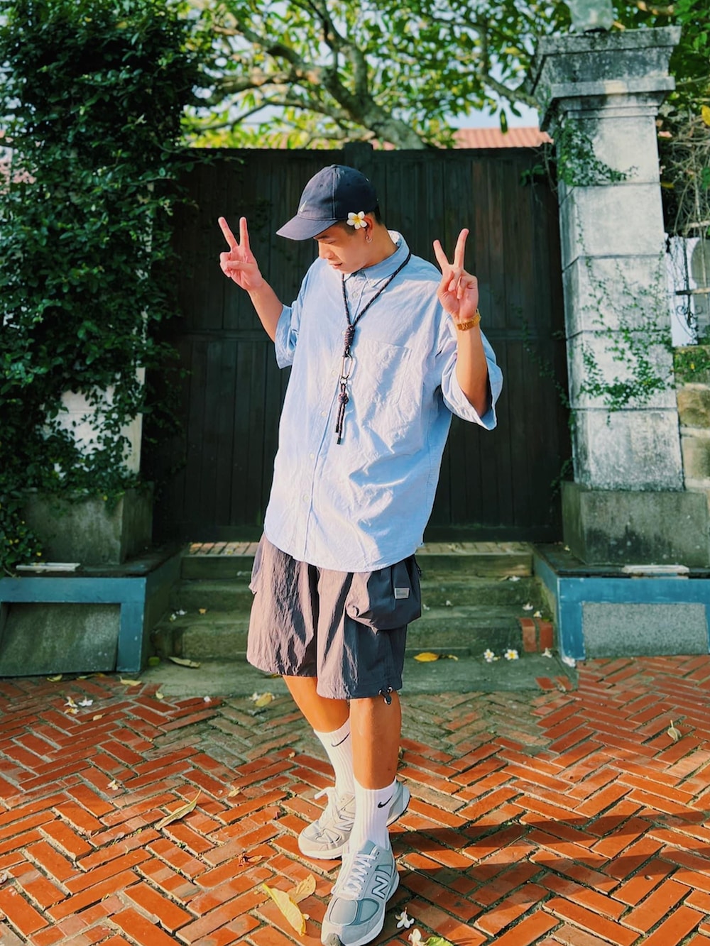 ブルー系のシャツ/ブラウス、グレー系のスニーカー、ブルー系のキャップを着用したメンズの夏コーディネートの3枚目の写真