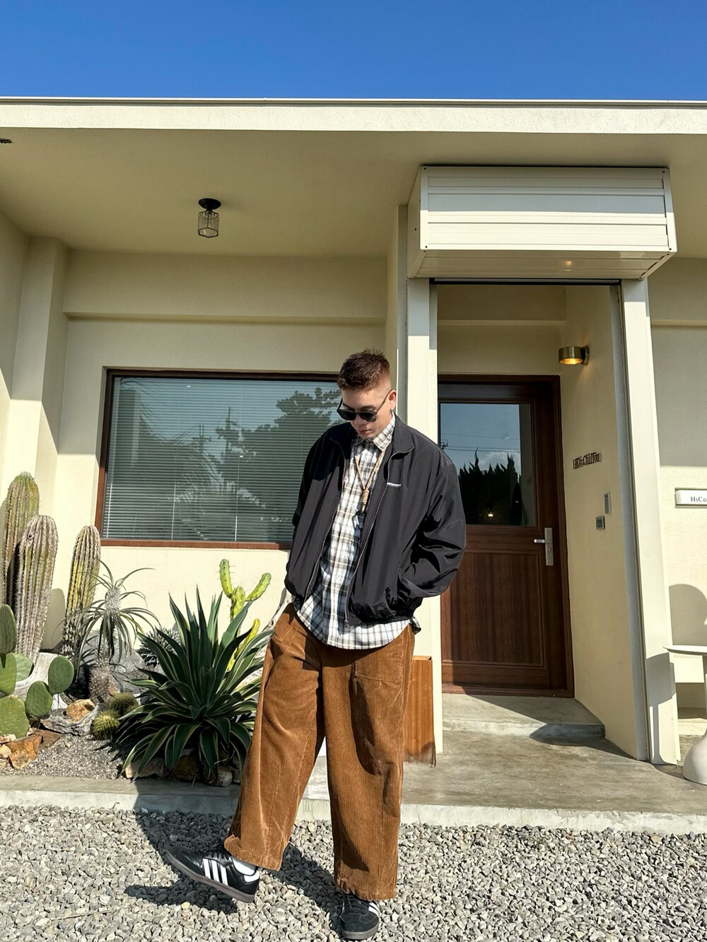 ブラック系のジャケット/アウター、ブラック系のスニーカー、グリーン系のサングラスを着用したメンズの冬コーディネートの3枚目の写真