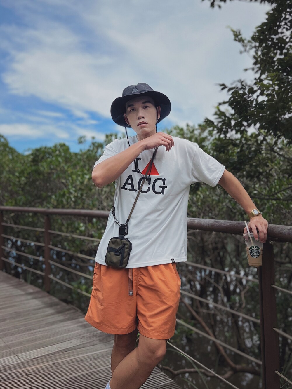 ホワイト系のTシャツ/カットソー、オレンジ系のその他パンツ、シルバー系のスニーカーを着用したメンズの夏コーディネートの2枚目の写真