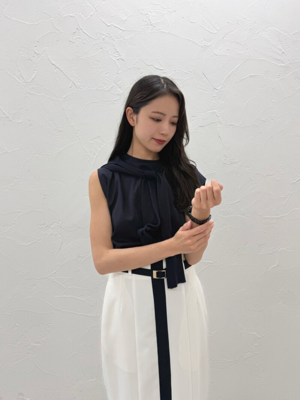 ホワイト系のスカート、ブラック系のTシャツ/カットソー、ブラック系のカーディガン/ボレロを着用したレディースの夏コーディネートの4枚目の写真