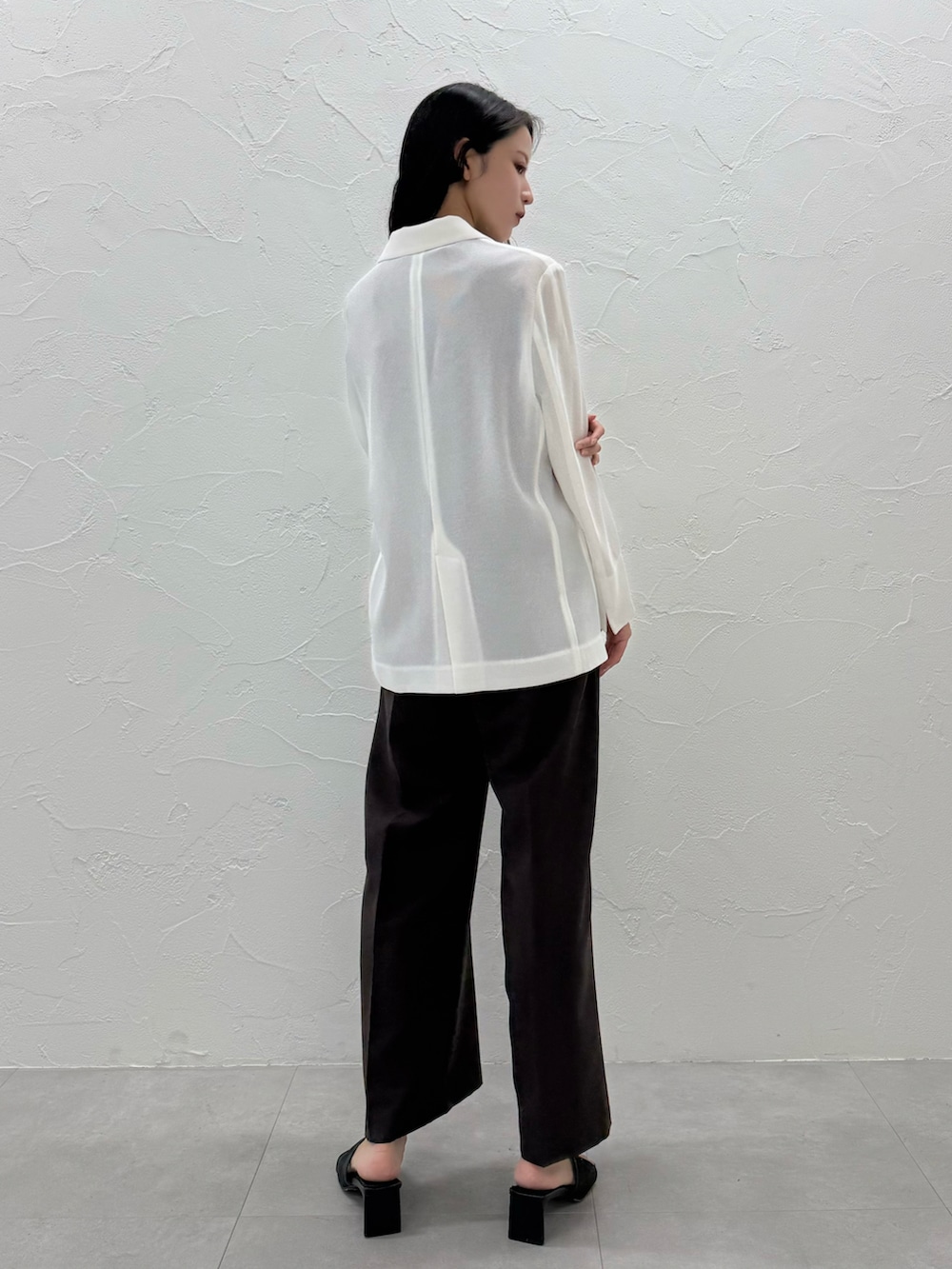 ブラック系のスラックス、ホワイト系のテーラードジャケット、ブラック系のTシャツ/カットソーを着用したレディースの夏コーディネートの3枚目の写真