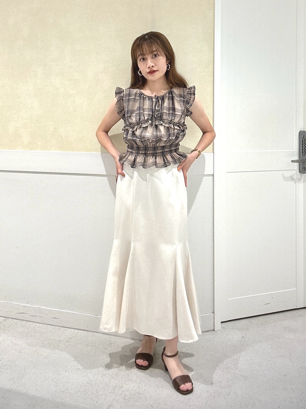 ホワイト系のスカート、ベージュ系のシャツ/ブラウス、ブラウン系のサンダルを着用したレディースの夏コーディネートの2枚目の写真