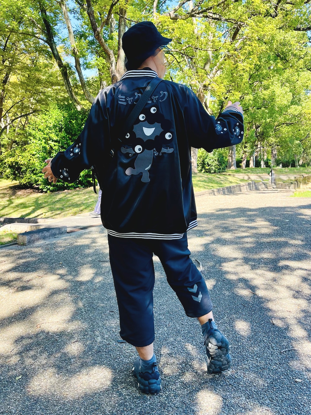 ブルー系のスカジャン、ブラック系のその他パンツ、グレー系のスニーカーを着用したメンズの秋コーディネートの4枚目の写真