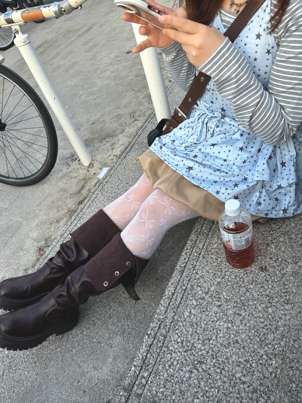 ブルー系のキャミソール、グレー系のトップス、ベージュ系のスカートを着用したレディースの春コーディネートの4枚目の写真