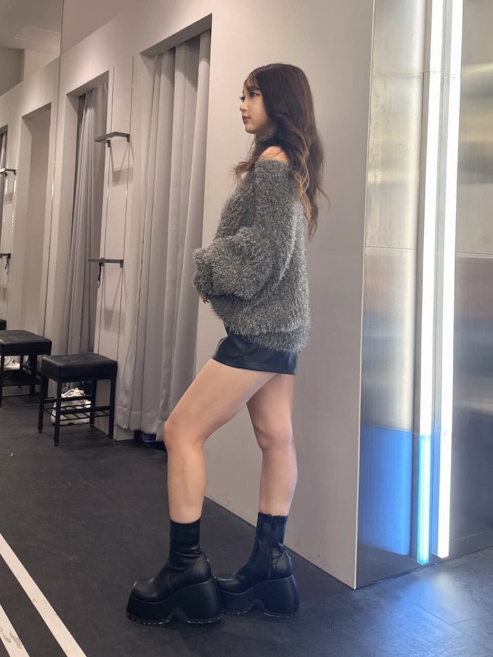 ブラック系のその他パンツ、ブラック系のブーツ、グレー系のニット/セーターを着用したレディースの秋コーディネートの2枚目の写真