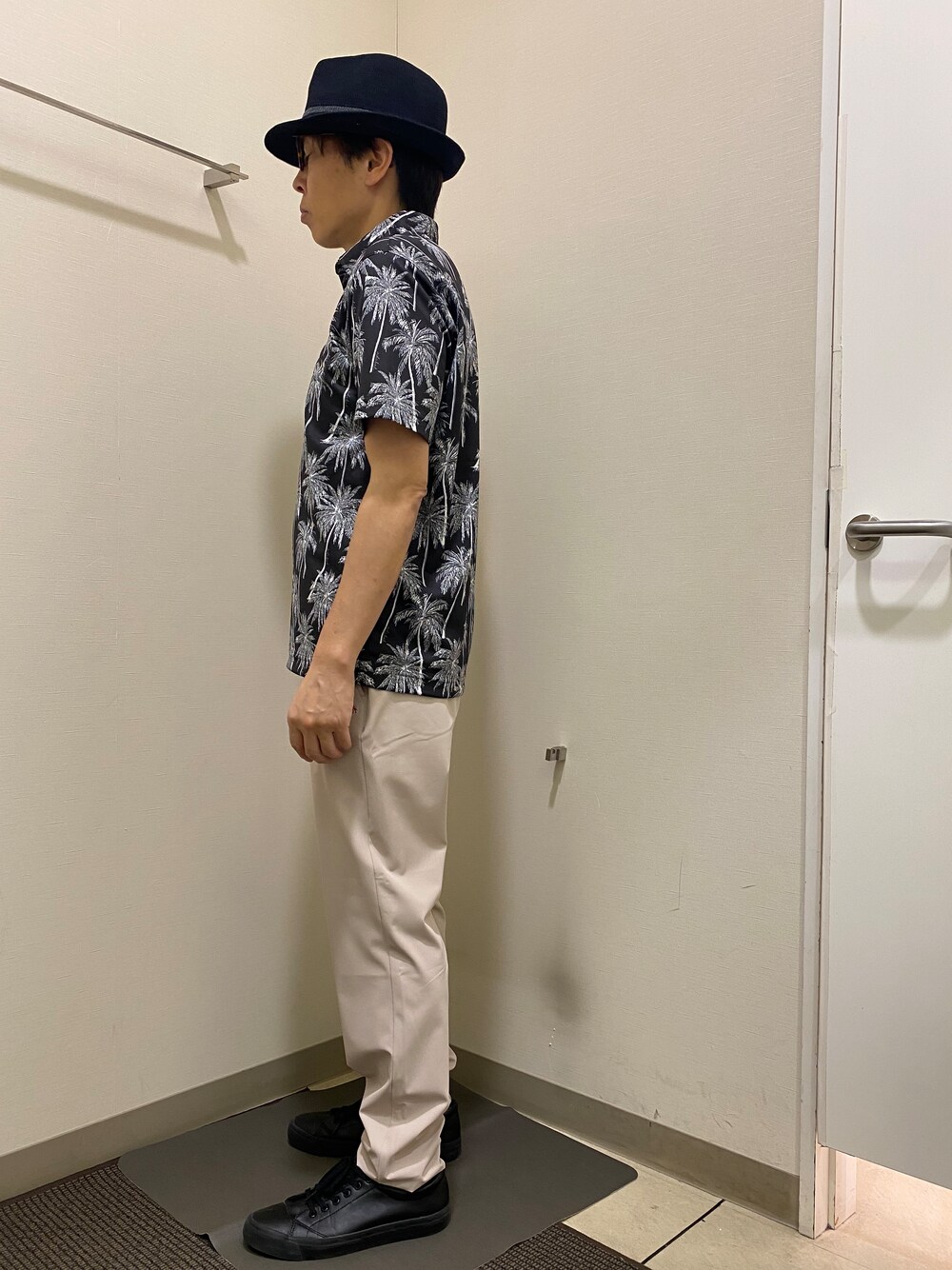 ブラック系のポロシャツ、ベージュ系のその他パンツ、ブラック系のハットを着用したメンズの春コーディネートの2枚目の写真