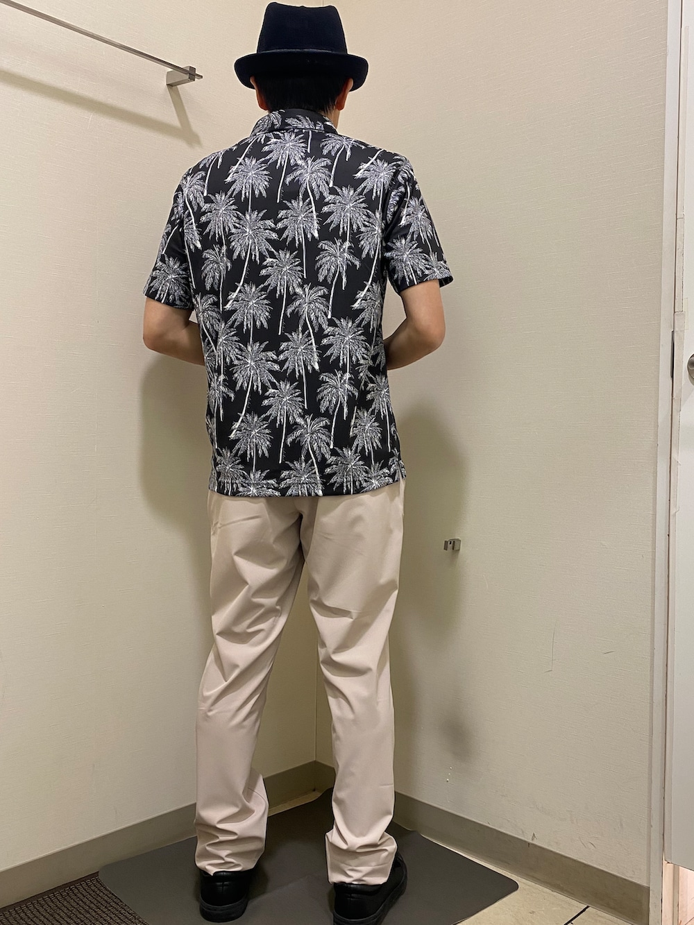 ブラック系のポロシャツ、ベージュ系のその他パンツ、ブラック系のハットを着用したメンズの春コーディネートの3枚目の写真
