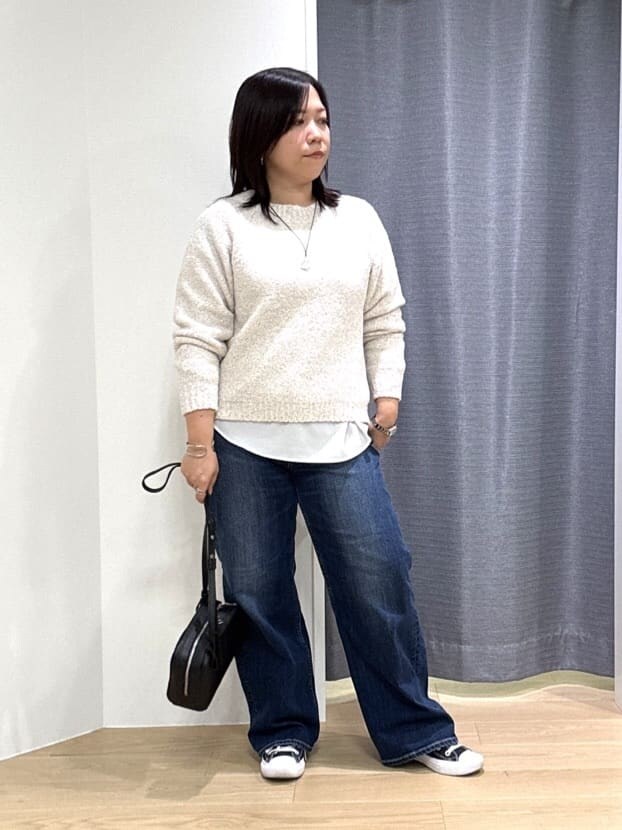 ホワイト系のショルダーバッグ、ホワイト系のニット/セーター、ブルー系のデニムパンツを着用したレディースの冬コーディネートの2枚目の写真