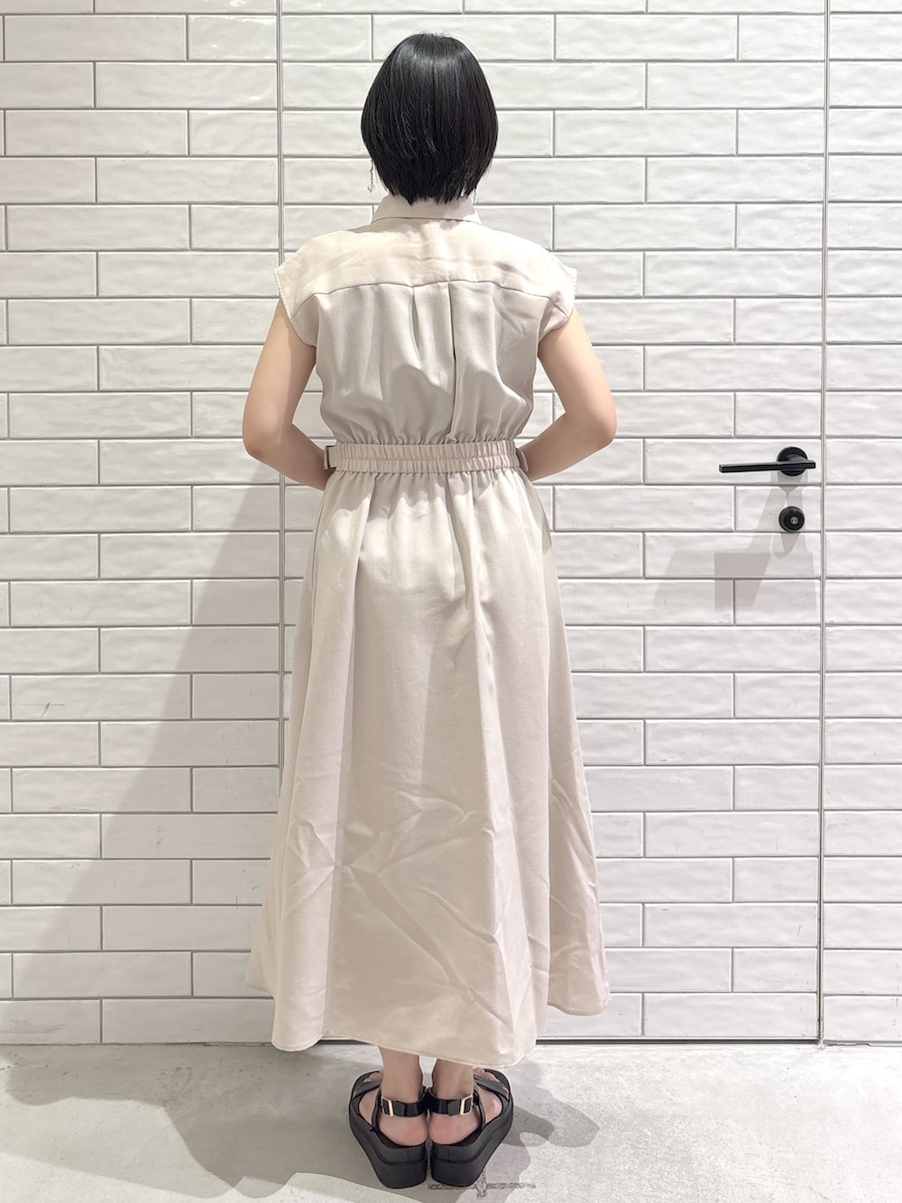ベージュ系のワンピース、ホワイト系のトートバッグ、ブラック系のサンダルを着用したレディースの夏コーディネートの3枚目の写真