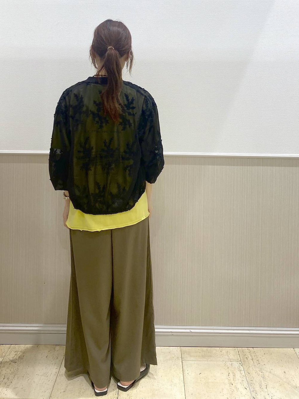 ブラック系のパンプス、ブラック系のブルゾン、イエロー系のTシャツ/カットソーを着用したレディースの春コーディネートの4枚目の写真
