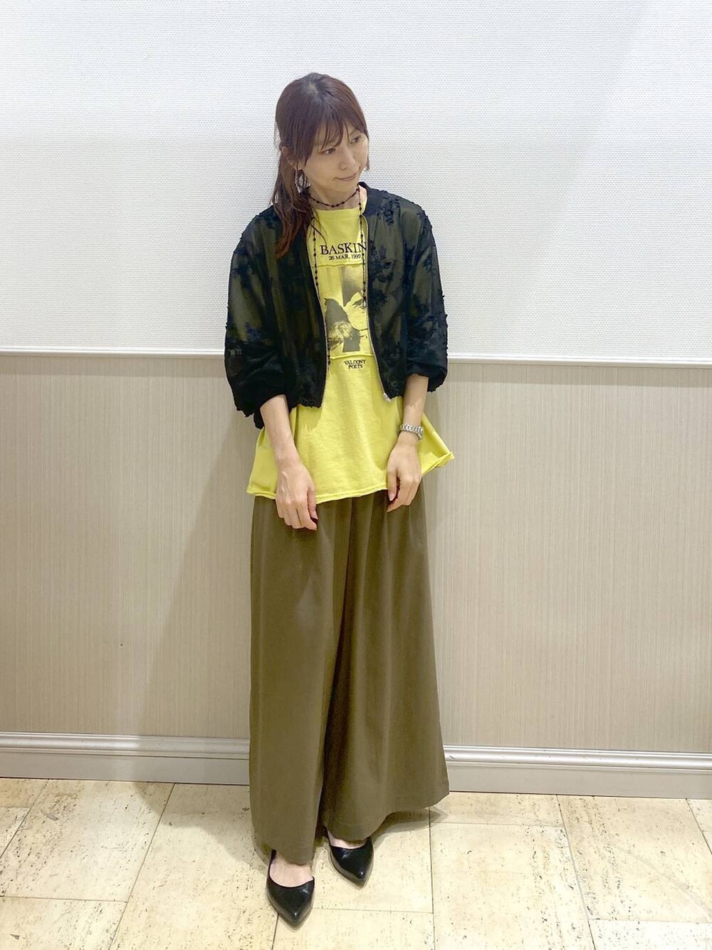 ブラック系のパンプス、ブラック系のブルゾン、イエロー系のTシャツ/カットソーを着用したレディースの春コーディネートの6枚目の写真