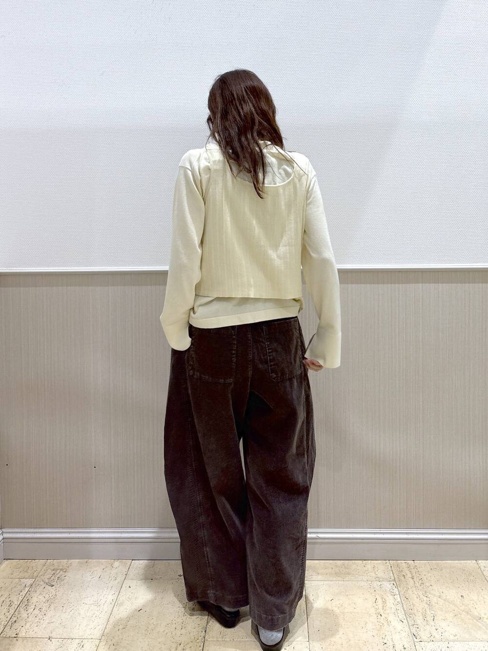 ホワイト系のニット/セーター、ブラウン系のその他パンツ、ブラック系のその他シューズを着用したレディースの秋コーディネートの4枚目の写真