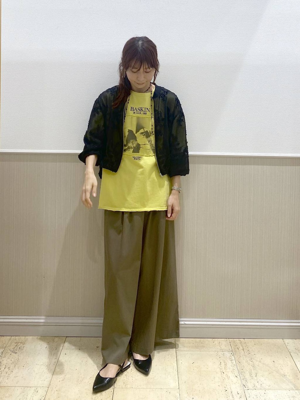 ブラック系のパンプス、ブラック系のブルゾン、イエロー系のTシャツ/カットソーを着用したレディースの春コーディネートの2枚目の写真