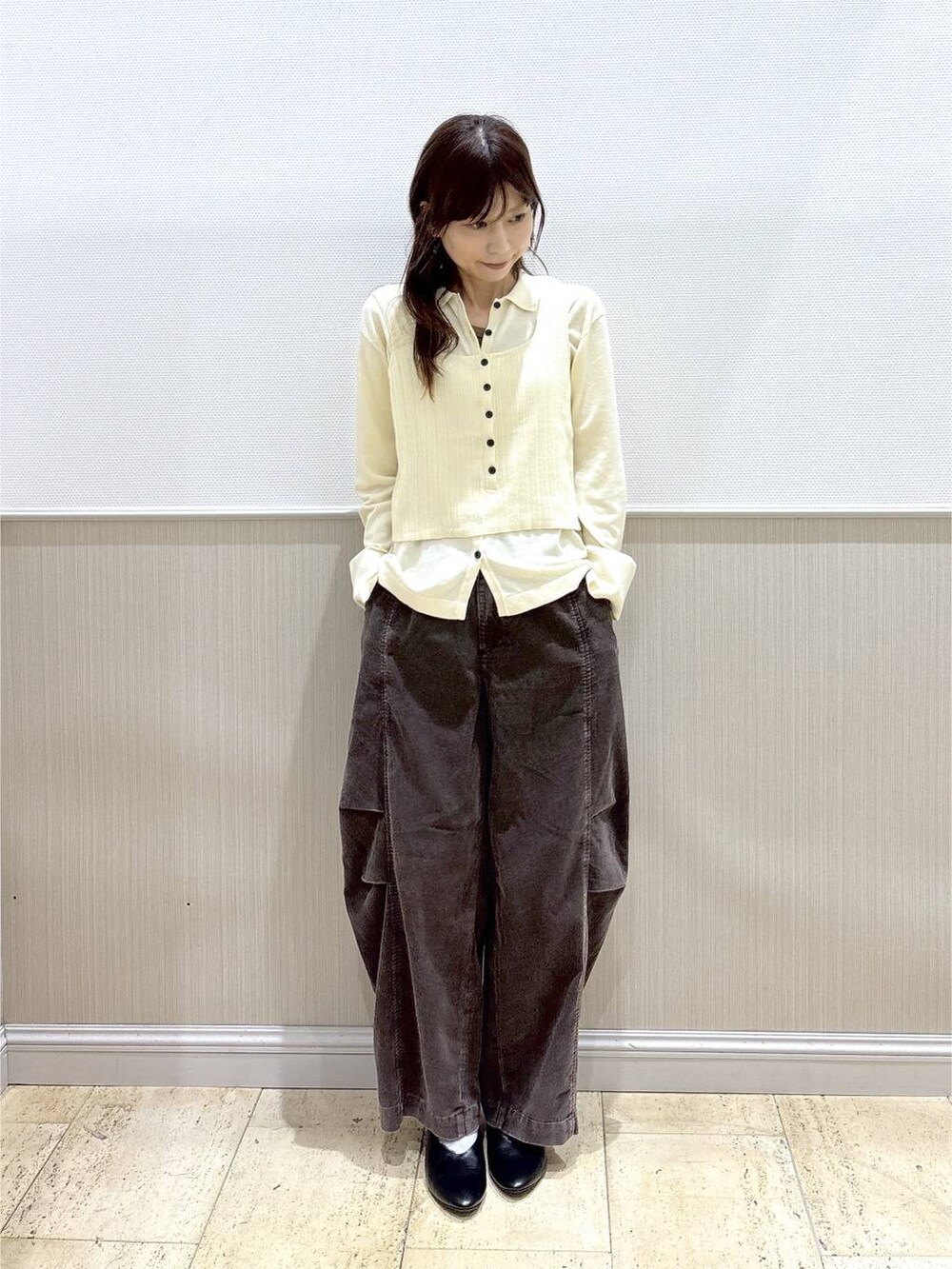 ホワイト系のニット/セーター、ブラウン系のその他パンツ、ブラック系のその他シューズを着用したレディースの秋コーディネートの2枚目の写真