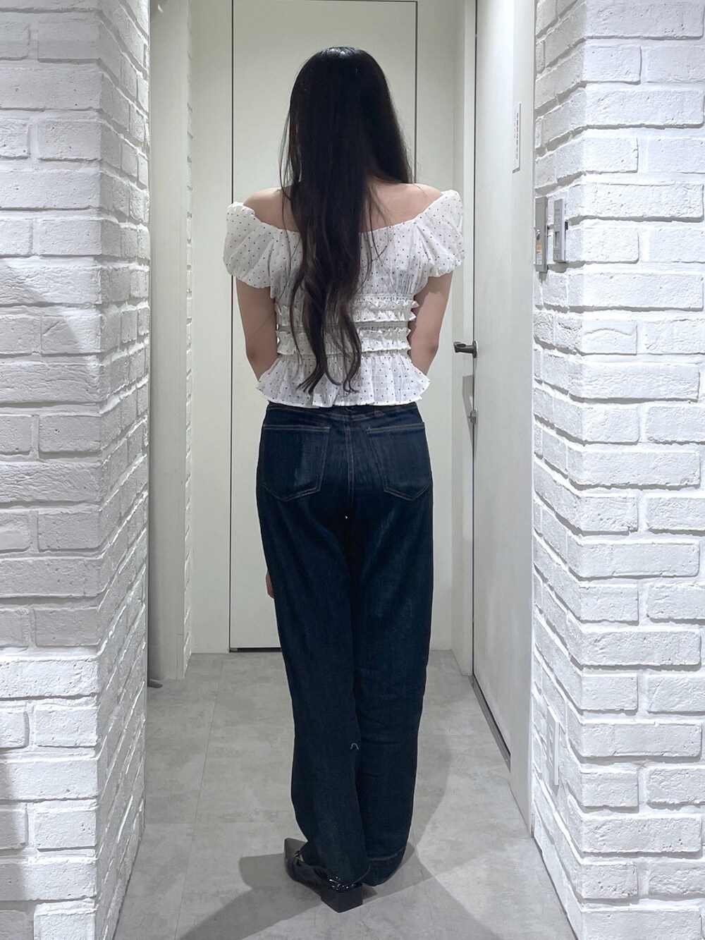 ホワイト系のシャツ/ブラウス、ブラック系のパンプス、ブルー系のデニムパンツを着用したレディースの夏コーディネートの5枚目の写真
