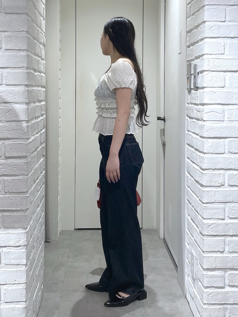 ホワイト系のシャツ/ブラウス、ブラック系のパンプス、ブルー系のデニムパンツを着用したレディースの夏コーディネートの4枚目の写真