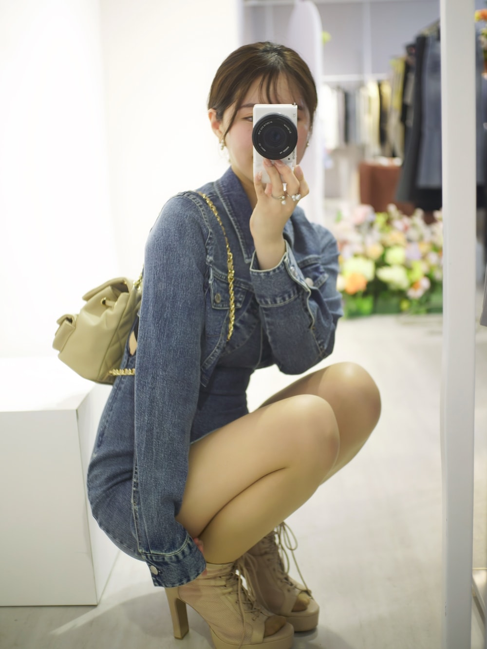 ブルー系のワンピース、ベージュ系のブーツ、ベージュ系のバックパック/リュックを着用したレディースの春コーディネートの6枚目の写真